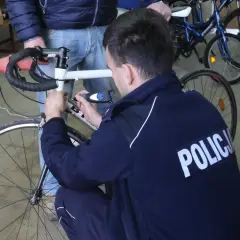 Policjant sprawdza rower, by ustalić, jak sprawdzić czy rower nie jest kradziony.