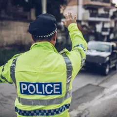 Policjant w odblaskowej kamizelce kieruje ruchem. Może to być kontrola drogowa, która przypomni o odsetkach za niezapłacony mandat w Niemczech.