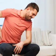 Mann mit Rückenschmerzen sucht nach hallux schmerzen lindern hausmittel.