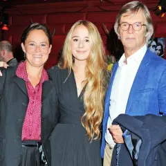 Bille Augusts barn, en kvinna och en ung flicka, poserar med en man i blå kavaj.