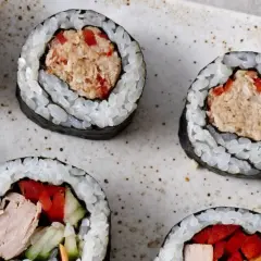 Roladki sushi z ryżem i nori, wypełnione rozdrobnionym tuńczykiem w sosie własnym, papryką i ogórkiem.