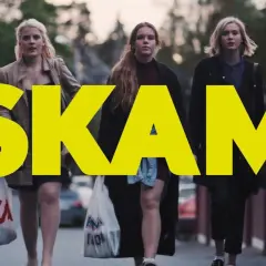 Fem tjejer går på gatan, med den stora gula texten "SKAM" över bilden. En av dem dricker ur en flaska.