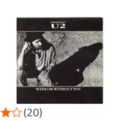 U2 w kadrze z piosenki "With or Without You". Mężczyzna w kapeluszu siedzi na ziemi, rzucając długi cień.