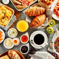 Un festin pour un brunch mariage : œufs brouillés, saumon fumé, croissants, fruits, café et jus d'orange.