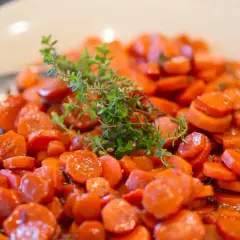 Carottes Vichy cookeo, tendres et glacées, garnies d'une branche de thym frais. Un délice simple et savoureux.