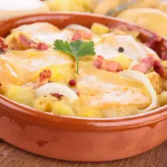 Plat gratiné avec pommes de terre, lardons et fromage à raclette fondant. Une recette réconfortante pour les soirées d'hiver.