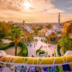 Park Güell w Barcelonie, jednym z największych miast Hiszpanii, zachwyca mozaikową ławką i bajkowymi budynkami o zachodzie słońca.