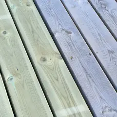 Trallen är delvis målad i en ljusgrå nyans, vilket ger en fin kontrast mot den obehandlade delen. Snart är hela trallen klar att njuta av.