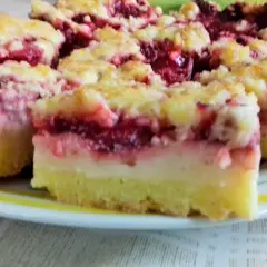Kruche ciasto z budyniem i owocami wiśni, posypane kruszonką. Pyszny deser na talerzu.