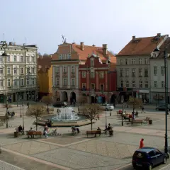 Rynek Wałbrzych tętni życiem. Ludzie odpoczywają przy fontannie, spacerują między kamienicami.