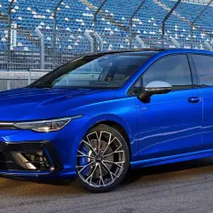 La Golf 8 R, avec ses nombreux chevaux, est prête à rugir sur le circuit, ses sièges bleus en arrière-plan attendant les spectateurs.