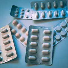 Kilka opakowań leków, w tym antydepresanty, leżą na jasnym tle.