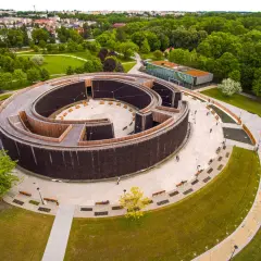 Nowoczesne termy w Busku-Zdroju, spiralna tężnia z drewnianymi elementami i otaczający ją park.