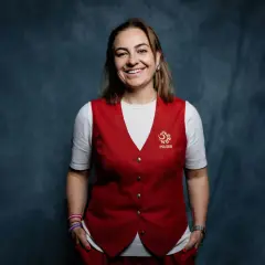 Uśmiechnięta kobieta w kamizelce z godłem Polski, część sztabu szkoleniowego reprezentacji Polski.