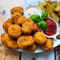 Chrupiące nuggetsy z kurczaka, złociste frytki i sosy: ketchup i majonez. Idealna przekąska na każdą okazję.
