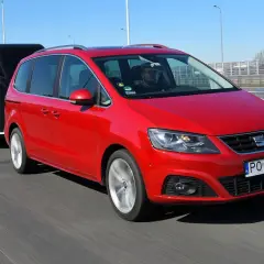 Czerwony Seat Alhambra z przyczepą na autostradzie. Zastanawiasz się, ile możesz jechać z przyczepą na autostradzie?