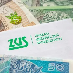 Koperta ZUS na tle polskich banknotów. Pytanie: ile czasu ma pracodawca na wypłacenie chorobowego?