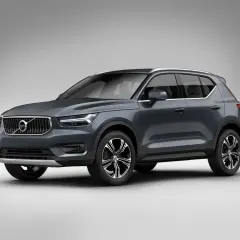 Elegancki, ciemnoszary Volvo XC40 prezentuje się na tle jasnej ściany, gotowy na miejskie wyzwania.