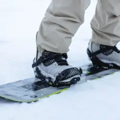 Zbliżenie na buty snowboardowe w wiązaniach. Dowiedz się, jak ustawić wiązania snowboard, by cieszyć się jazdą.