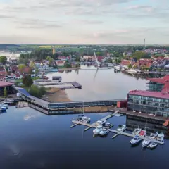 Malownicze miasta na Mazurach z nowoczesną architekturą i licznymi łodziami przy nabrzeżu.