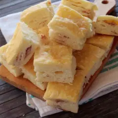 Sfiziose fette di gnocco fritto al forno, con un ripieno di prosciutto, pronte per essere gustate.