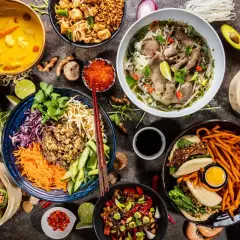 Vielfalt an asiatischem Essen: Pho, Frühlingsrollen, gedämpfte Teigtaschen, gebratene Nudeln und mehr.