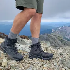 Hiking boots on a rocky summit. These boots look like they could last for years, answering the question: how long do leather boots last?