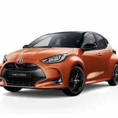 Toyota Yaris Hybrid naranja con llantas negras. Asegúrate de revisar la presión de los neumáticos para un viaje seguro.
