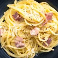 Spaghetti Carbonara mit Speck und Parmesan, ein Gericht, das man leicht perfekt zubereiten kann, wenn man die 10 Fehler beim Pasta kochen vermeidet.