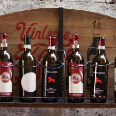 Eine Auswahl der besten Weine der Toskana, präsentiert auf einem rustikalen Holzschild.