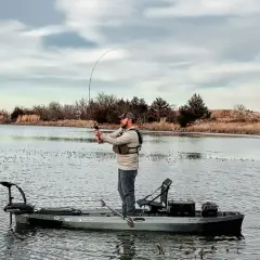 Pescatore su kayak con motore elettrico. Ottimo consiglio batteria motore elettrico per lunghe battute di pesca.