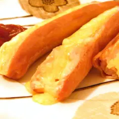 Parówki zapiekane z serem, z dodatkiem ketchupu, wyglądają apetycznie.