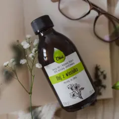 Butelka z naturalnym olejem z wiesiołka, idealnym do pielęgnacji włosów. Delikatne kwiaty podkreślają jego naturalne pochodzenie.