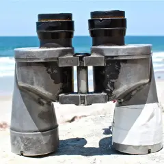 Binocolo sulla spiaggia, pronto a scrutare l'orizzonte. A cosa serve il binocolo? A vedere lontano, a scoprire dettagli nascosti nel paesaggio marino.
