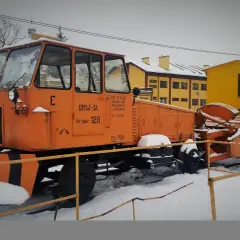 Pomarańczowy pług kolejowy OMW-3A z numerem fabrycznym 128, gotowy do pracy zimą.