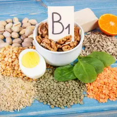 Vielfalt an vitamin b1 lebensmittel: Nüsse, Linsen, Reis, Erbsen, Ei, Spinat, Sonnenblumenkerne, Orange und Hefe.