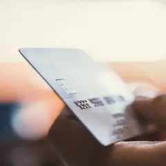 Dłoń trzyma kartę płatniczą. Zastanawiasz się, moneyback co to? To zwrot części pieniędzy za zakupy.