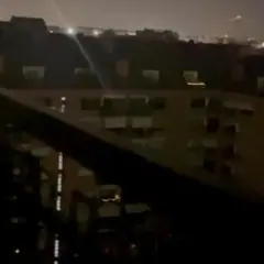 Un panorama notturno di Torino, con luci soffuse che illuminano i palazzi e un cielo velato.