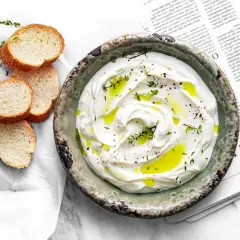 Labneh co to? Kremowy serek jogurtowy, skropiony oliwą, z ziołami i pieprzem, podany z chrupiącymi grzankami.