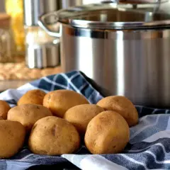 Ziemniaki na ręczniku, garnek w tle. Czas zacząć gotowanie, ale kiedy solić ziemniaki?