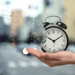 Budzik rozpada się na kawałki w dłoni, jakby czas uciekał, zanim nadejdzie pensja.