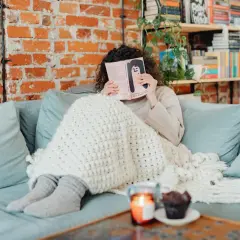 Idealny wyjazd na weekend: przytulny koc, dobra książka i chwila relaksu na kanapie.