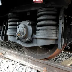Podwozie lokomotywy z widocznymi sprężynami i elementami układu hamulcowego. Masa hamująca wymagana do bezpiecznej jazdy.