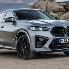 Srebrne x6 BMW z czarnymi felgami na tle skalistego krajobrazu.