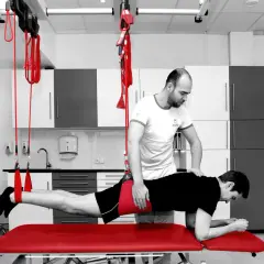 Fizjoterapeuta pomaga pacjentowi w ćwiczeniach rehabilitacyjnych, które mogą być częścią leczenia koślawości bioder.