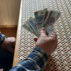 Dłoń trzyma polskie banknoty. Czy to odpowiedź na pytanie, ile zarabia opiekun wytchnieniowy?