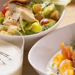 Ensalada César con pollo y huevo duro, acompañada de una cremosa salsa césar vegana.