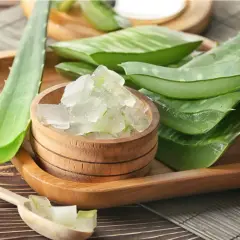 Aloe vera para el pelo: hojas frescas y gel cortado en cubos en un cuenco de madera, listo para usar.
