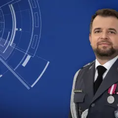 Mężczyzna w mundurze, wyższy stopień podoficerski w marynarce wojennej, z odznaczeniami. Tło z elementami graficznymi przypominającymi radar.