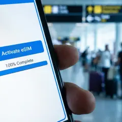 Aktywacja eSIM na telefonie w tle lotniska, gotowość do podróży i roaming Ukraina.